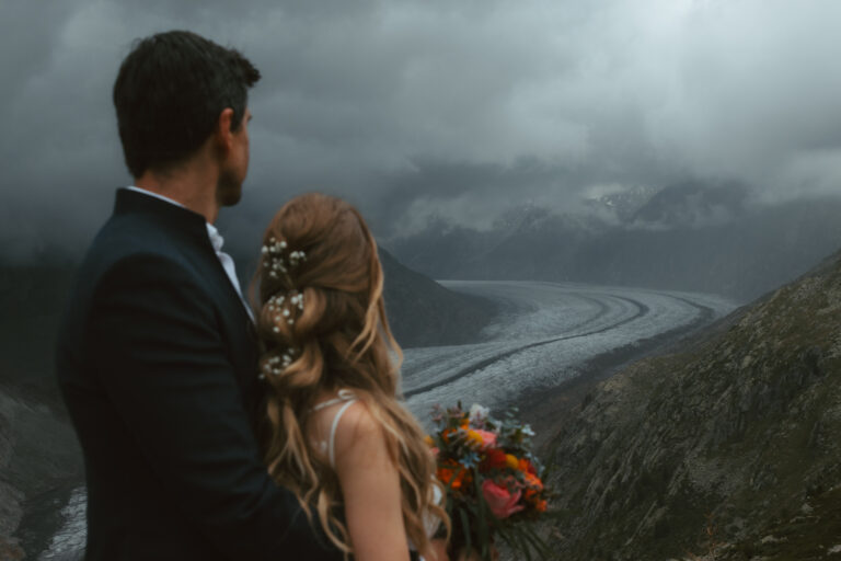 An eloping couple looks off into the distance during their glacier elopement in Switzerland