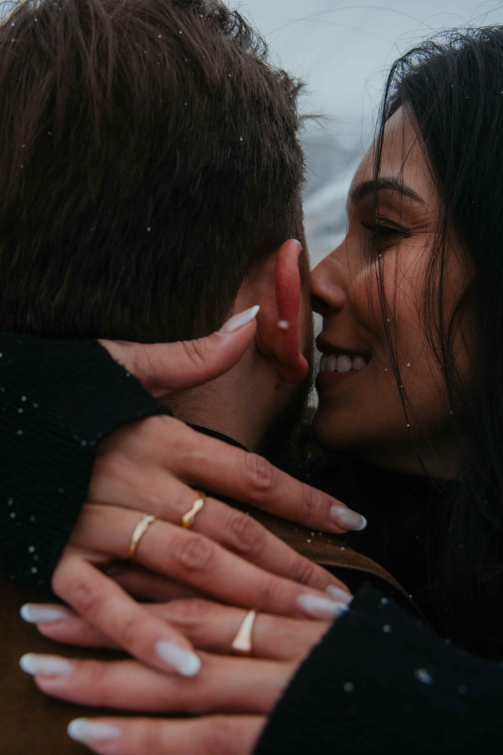 A couple embraces tightly in the snow