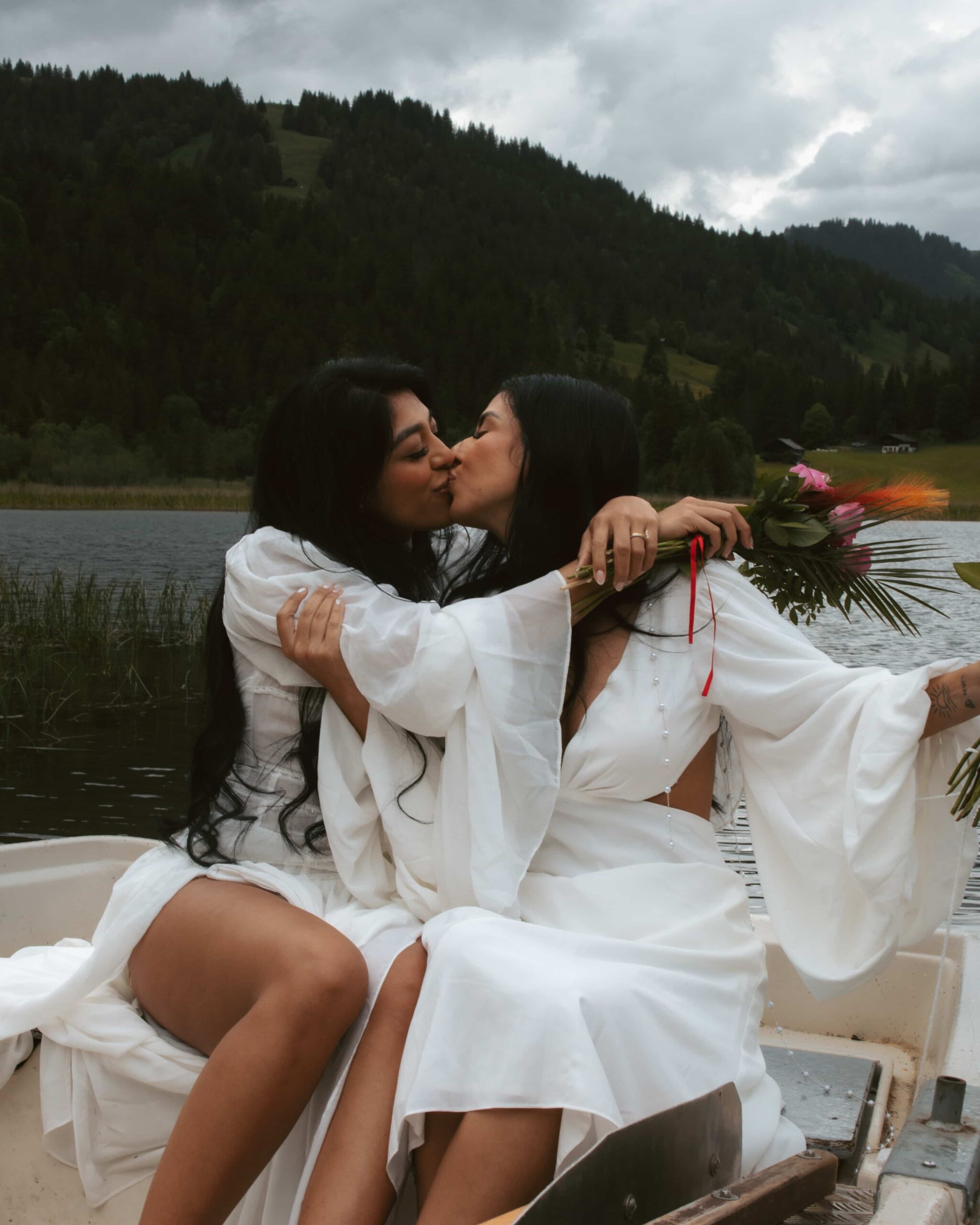 During their elopement, a couple kisses on a rowboat on a swiss alpine lake